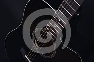Black acoustic guitar studio shot on black background with copyspace, Guitar is favorite music