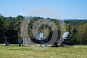 Black Adirondack Chairs on Green Grass Outdoors in the Mountains