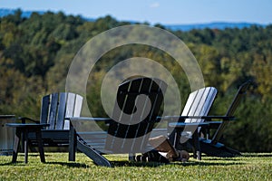 Black Adirondack Chairs on Green Grass Outdoors in the Mountains