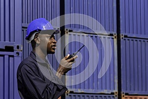 Black african amarican man worker working control loading freight containers at commercial shipping dock. cargo freight dock and