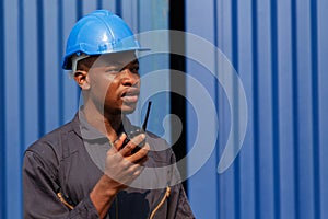 black african amarican man worker working control loading freight containers at commercial shipping dock. cargo freight dock and