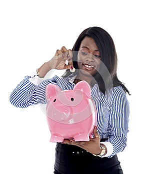 Black African American business woman putting coin into oversized pink piggybank