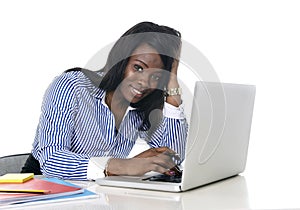 Black african american ethnicity woman working at computer laptop at office desk smiling happy