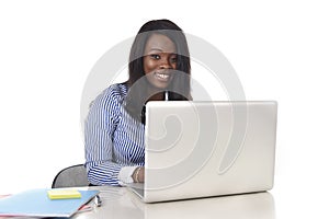 Black african american ethnicity woman working at computer laptop at office desk smiling happy