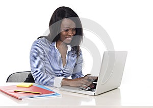 Black african american ethnicity woman working at computer laptop at office desk smiling happy