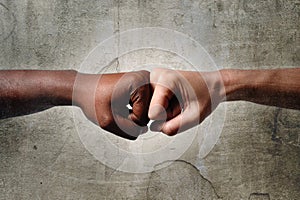 Black African American race female hand touching knuckles with white Caucasian woman in multiracial diversity