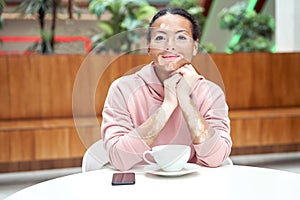 Black african american woman with vitiligo pigmentation skin problem indoor dressed pink hoodie photo