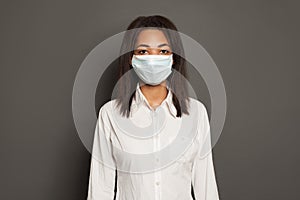 Black African American woman wearing a face mask on yellow background. Woman in medical mack. Flu epidemic and virus protection photo