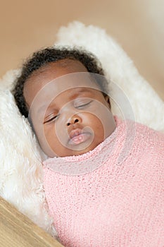 Black african baby girl napping wrapped up studio closeup