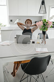 Black African businesswoman relaxing, stretching, working from home