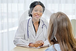 Black African female doctor consulting with European patient about her health in hospital