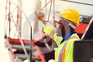 Black African port shipping staff director working in logistic control loading containers at ship cargo for import export goods