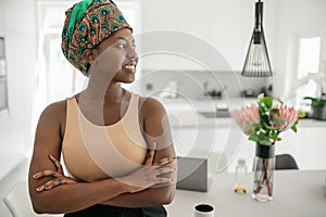 Black African woman at home arms crossed, looking into copy space