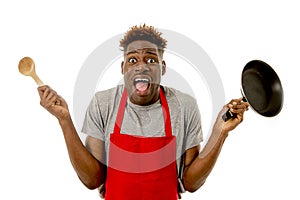 Black afro american man home cook in chef apron cooking pan and spoon lost and overworked