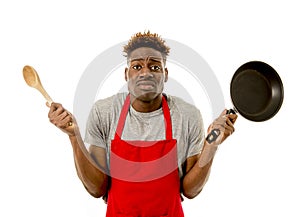 Black afro american man home cook in chef apron cooking pan and spoon lost and overworked