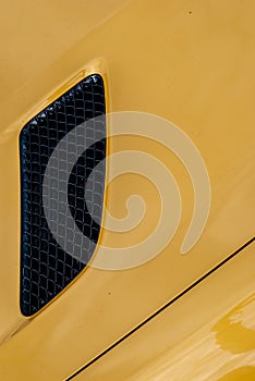 Black air intake grid of yellow sport turbo car