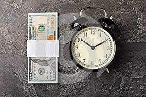 Black alarm clock on money banknotes Dollars, business planning and finance concept. Time is money.