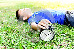 Black alarm clock and sleeping boy in the park