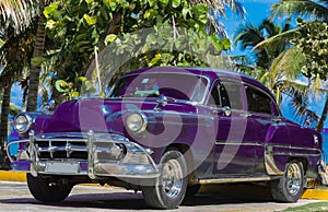 Black american Oldtimer parked under palms near the beach in Varadero Cuba - Serie Cuba 2016 Reportage