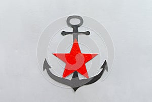 Black anchor with a red star on a gray iron background