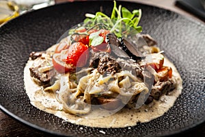 Black Angus beef tagliatelle pasta with fresh black truffles and parmegano. Delicious healthy traditional food closeup