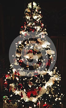 Black Artificial Christmas Tree Decorated With Decorations And Lights