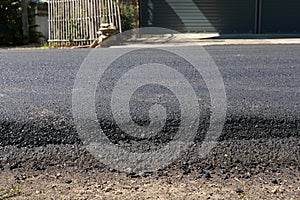 Black asphalt construction road surface level with tarmac