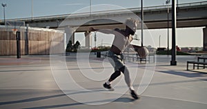 Black athlete doing tricks on streetball court