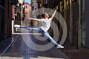 Black athletic man doing an acrobatic jump outdoors