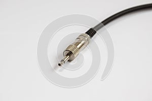 Black audio cable ,chrome jack plug on white backgroun