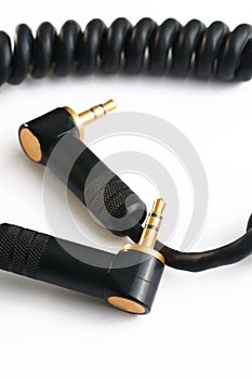 Black audio instrumental cable with two gold stereo plugs isolated on white close up