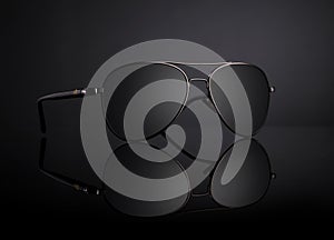 Black Aviator Sunglasses with Reflection on Black Background