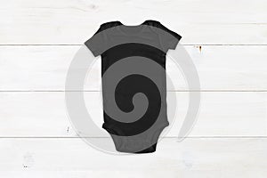 Black baby onesie mockup on white wood background photo