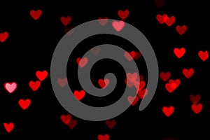 Black background with bright red warm heart shaped bokeh lights. Holiday, Valentines Day background. Ideal to layer with