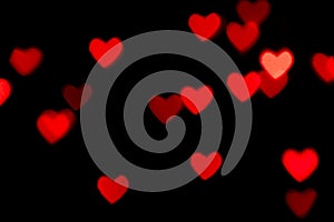 Black background with bright red warm heart shaped bokeh lights. Holiday, Valentines Day background. Ideal to layer with