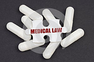 On a black background, capsules and a puzzle with the inscription - MEDICAL LAW