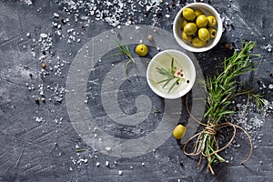 Black background cooking with olive oil, fresh herbs and spices, copy space, top view