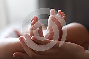 Black  background mother mom hold son new-born baby feet on palm hand maternal love family happiness concept