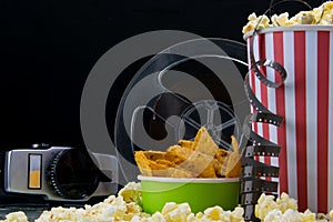 Black background, old video camera, popcorn, film, at the bar on the table