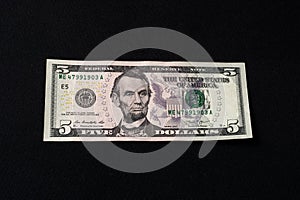On the black background is one bill in size five dollars