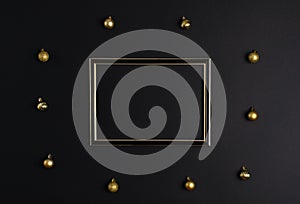 On a black background, a photo frame with a place for text, around there are golden Christmas balls