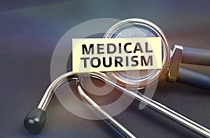 On a black background, a stethoscope, on which a sticker with the inscription - MEDICAL TOURISM