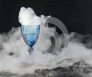 On a black background of transparent glass scattered white smoke.