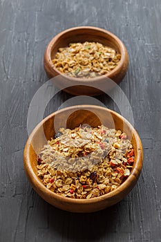 On a black background in wooden plates are muesli from sprouted grains of wheat, barley and rye, with the addition of