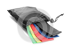Black bag with colorful elastic resistance bands isolated on white. Fitness equipment