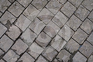 Black basalt paving which is wet because of the rain