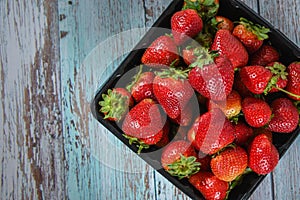 Black basket with a bunch of freshly strawberries.