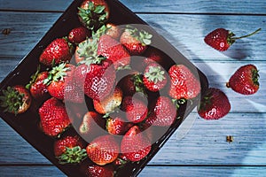 Black basket with a bunch of freshly strawberries.
