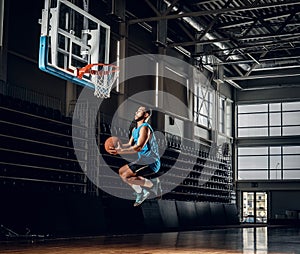 Black basketball player in action in a basketball court.