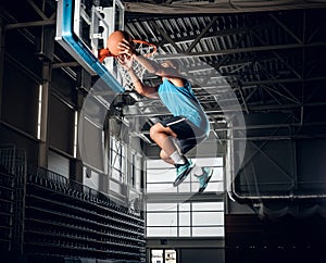 Black basketball player in action in a basketball court.